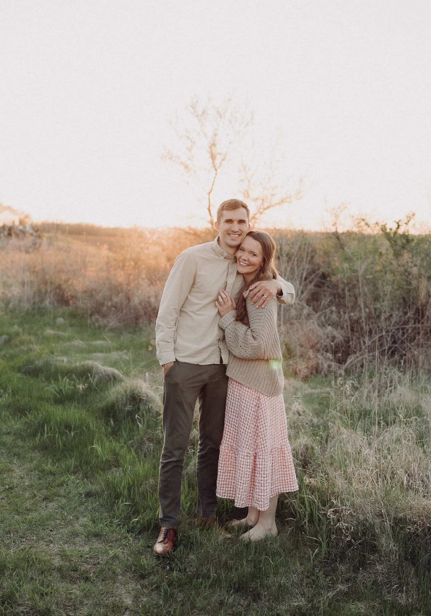 Xan and Nathaniel standing arm in arm in a field